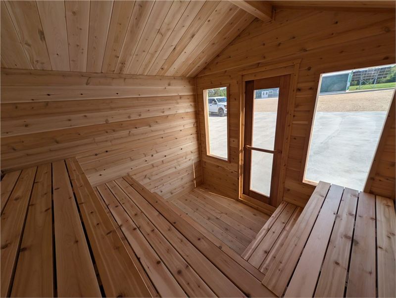 Intérieur du sauna Summit avec bancs en cèdre en L à trois niveaux