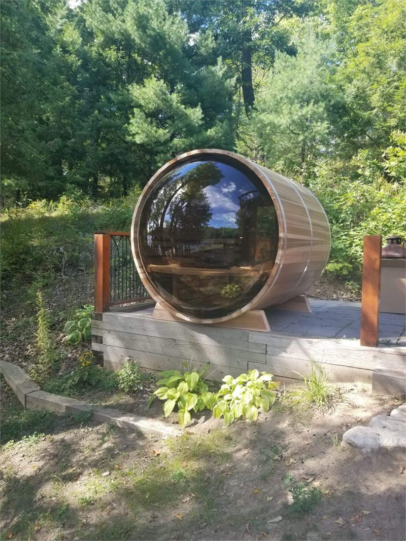 Sauna baril avec fenêtre panoramique dans un décor boisé